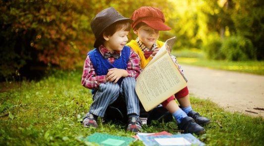Dos niños pequeños leyendo un libro