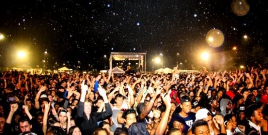 Multitud de personas bailando en un concierto a la luz de las estrellas