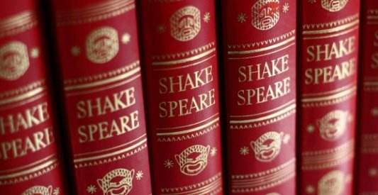 Serie de libros de las obras completas de William Shakespeare encuadernados en rojo.