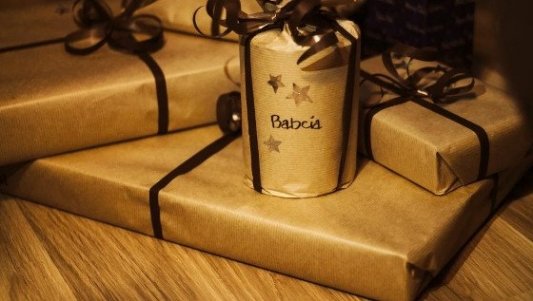 Varios regalos envueltos con papel marrón que podrían ser libros y una taza.