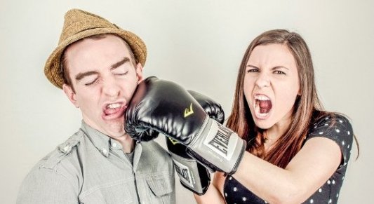 Representación en clave de comedia de una pelea en la que una mujer golpea a un hombre con guantes de boxeo.