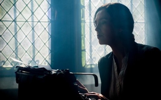 Escritora frente a una vieja máquina de escribir.