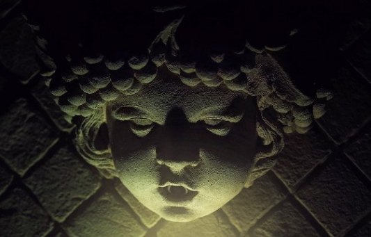 Escultura de un niño con luz siniestra.