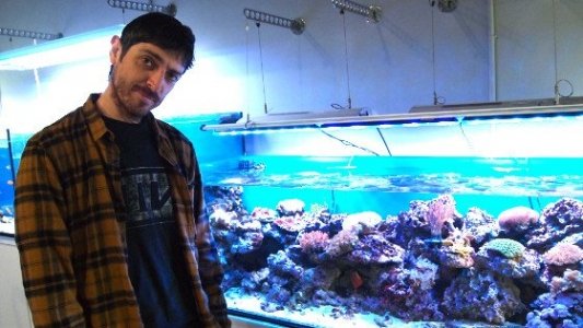 Emilio Bueso junto a un acuario con caracoles.