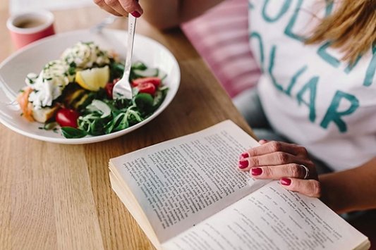Un lector lee y come una ensalada