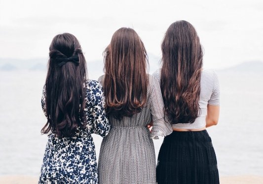 Tres chicas de espaldas con el mar de fondo