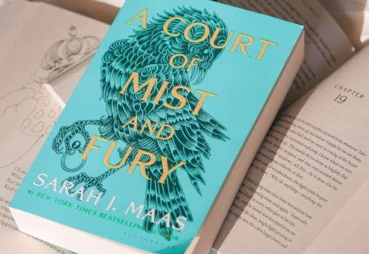Fotografía de A Court of Mist and Fury de Sarah J Maas sobre varios libros abiertos